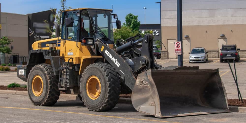 Komatsu wheel loader with a bucket attachment in a parking lot